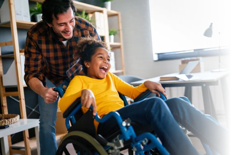 Happy family activities with disabled handicapped child in wheelchair
