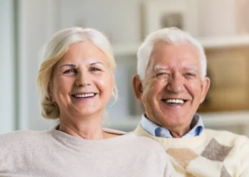 Smiling grey haired couple sitting.